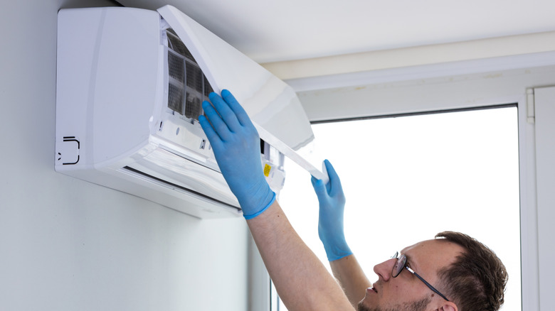 Technician cleaning a heat pump air conditioning unit