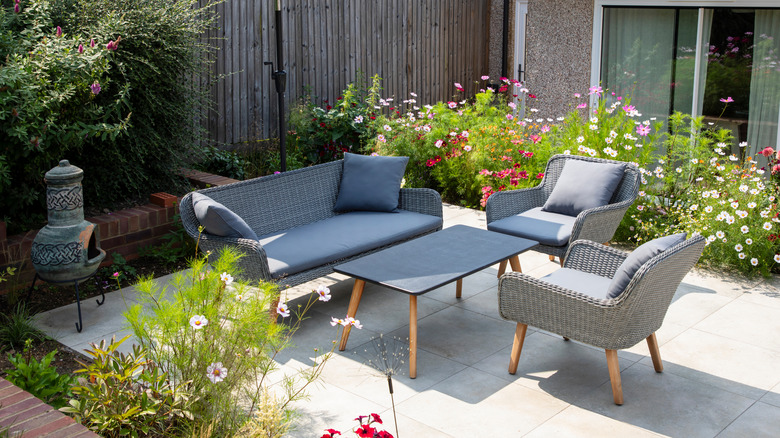 Porcelain tile patio with furniture in a garden.
