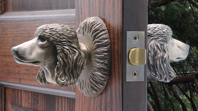silver poodle head door knob installed on a wood door