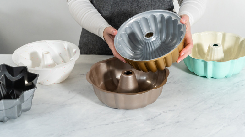 Person with several different Bundt pans