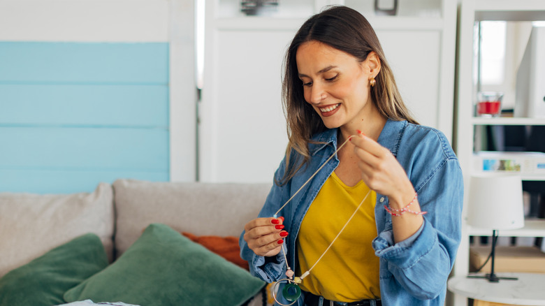 A woman organizes jewelry in a colorful room