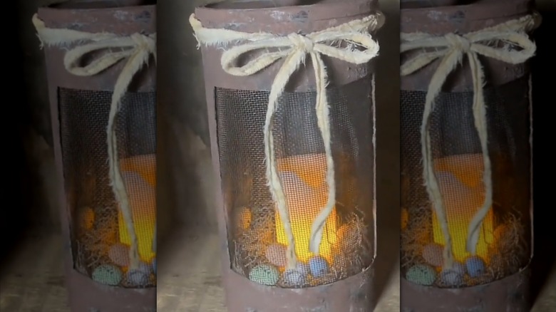 A rustic DIY dark lantern with moss, Easter eggs, and a tea light