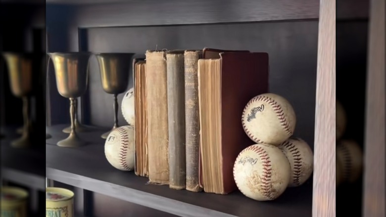 Baseballs glued together to create bookends on a shelf