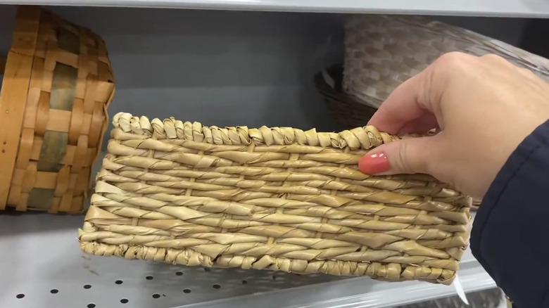Shopper reaching for a basket at a thrift store