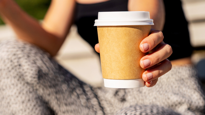 Person holding a paper cup