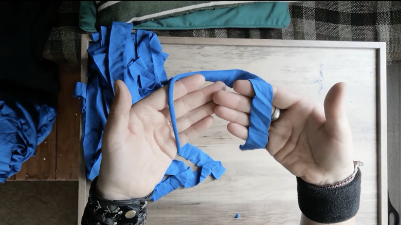 hands holding cut T-shirt strip