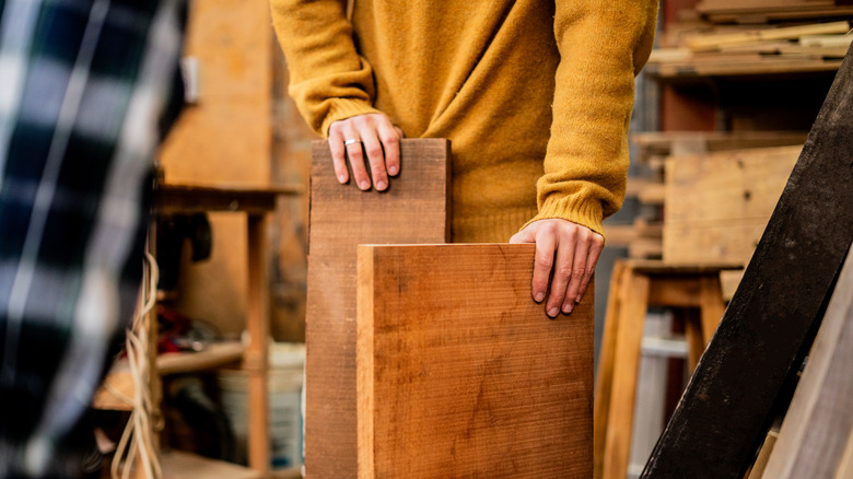 Person holding boards of wood