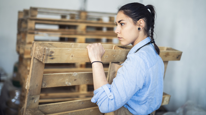 Person holding wood pallets