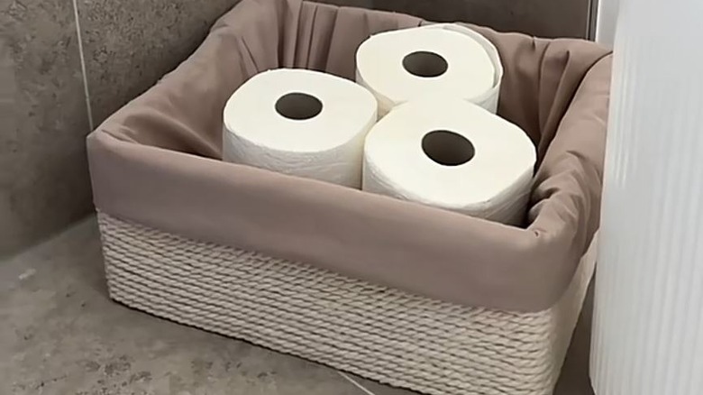Old pillowcase and cardboard box turned into toilet paper storage basket