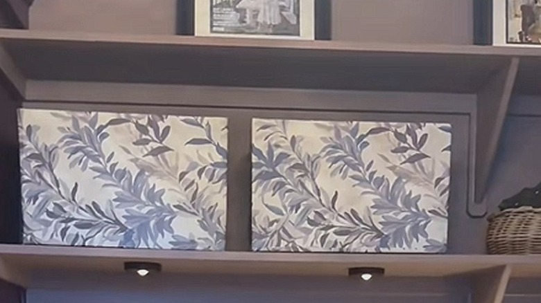 Two shipping boxes wrapped with florals on storage room shelf with hidden organized items