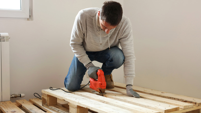 Man crafting with wooden pallet