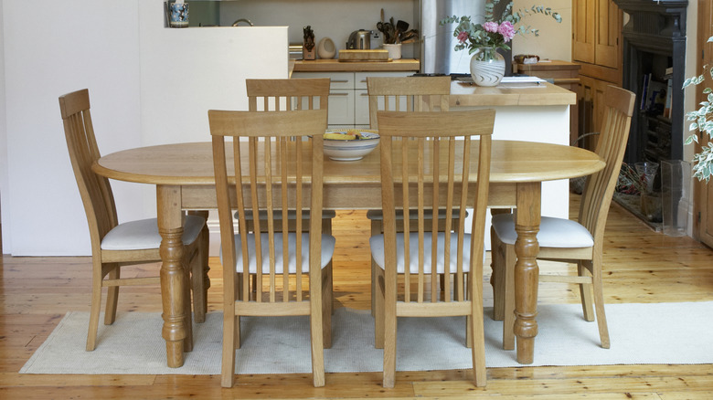 Light wood dining set in white room with runner