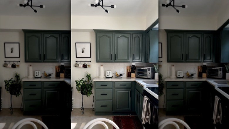 Pewter green kitchen cabinets with white countertop and walls
