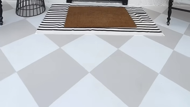 A painted white and beige front porch floor to look like checkerboard tiles