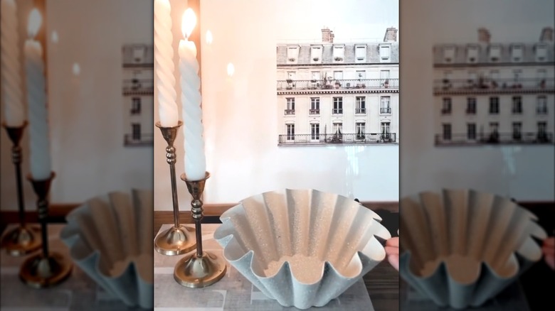 Scalloped, textured Bundt pan as centerpiece beside taper candles and classic decor