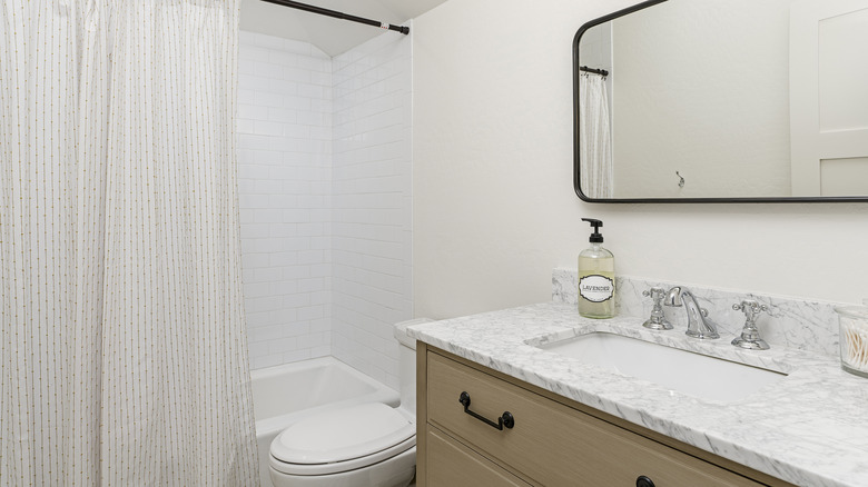 floor-to-ceiling shower curtain installed right near the ceiling in a modern bathroom