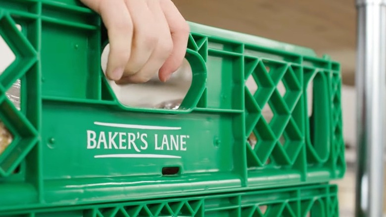 Person grabbing bread tray off of a stack