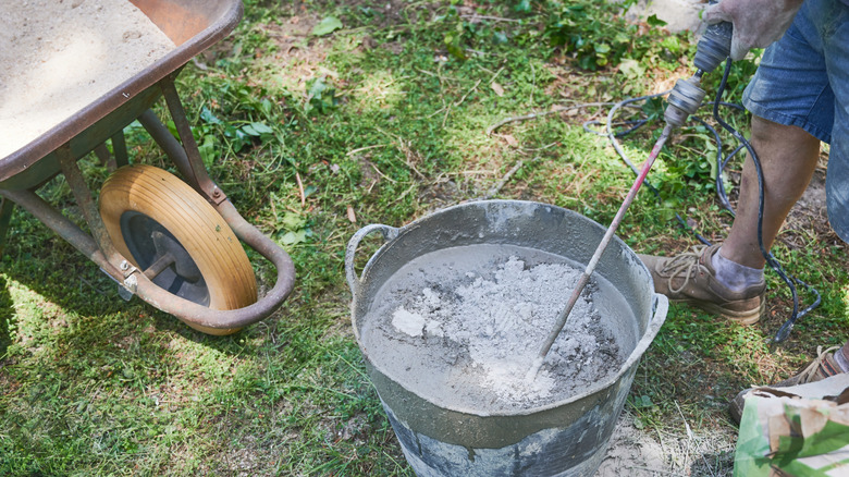 A person mixing mortar in a bucket