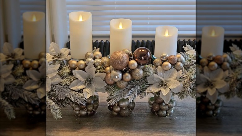 winter centerpiece with pool noodle base and decorated with candles, evergreen boughs, white floral, and clusters of ornaments