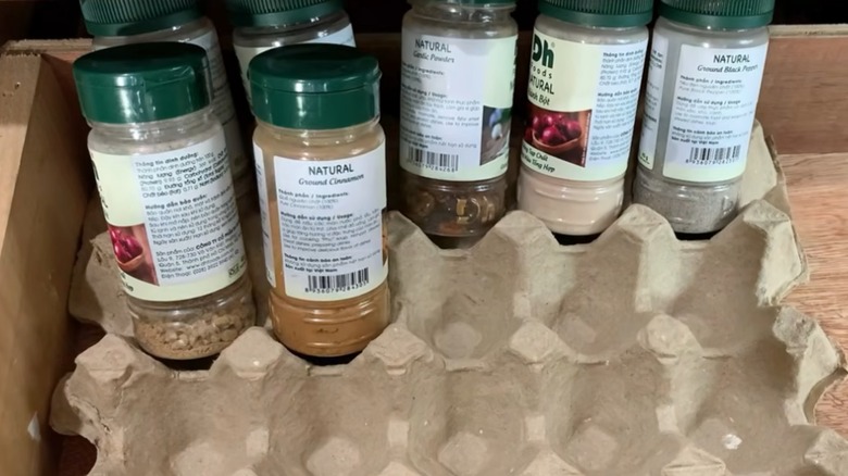 An egg carton used to sort spice jars in a drawer