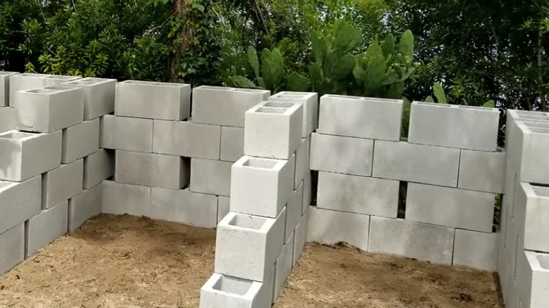 A close up of a finished 3-stage compost bin built using concrete blocks.