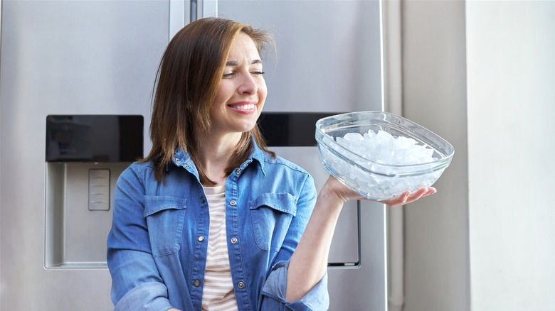 Smiling woman holding a bowl of ice cubes