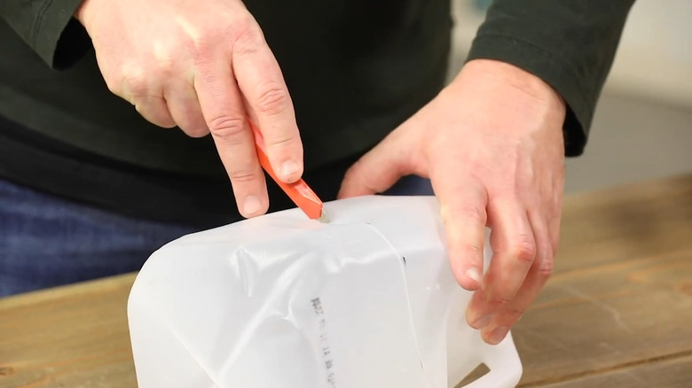 Person cutting a milk carton