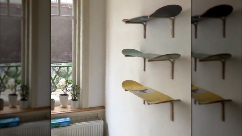 Three floating shelves made from skateboards on a wall