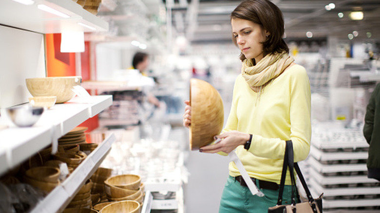 A woman shopping for wooden bowls