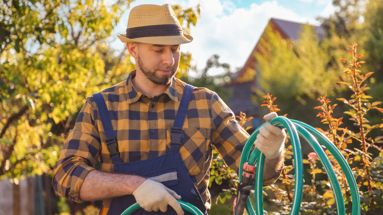 Man winding up a garden hose