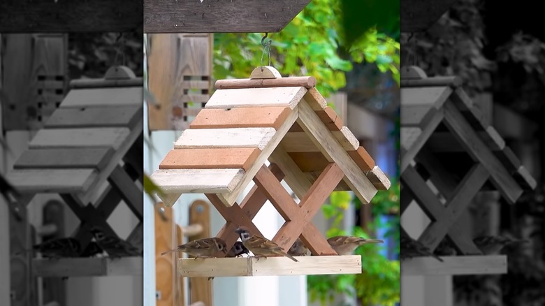 DIY bird feeder made from old pallet wood standing in a garden