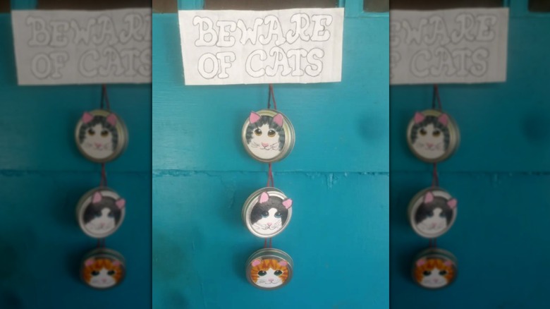 Door-hanging decor made of Mason jar lids decorated with cat faces and a "Beware of Cats" sign