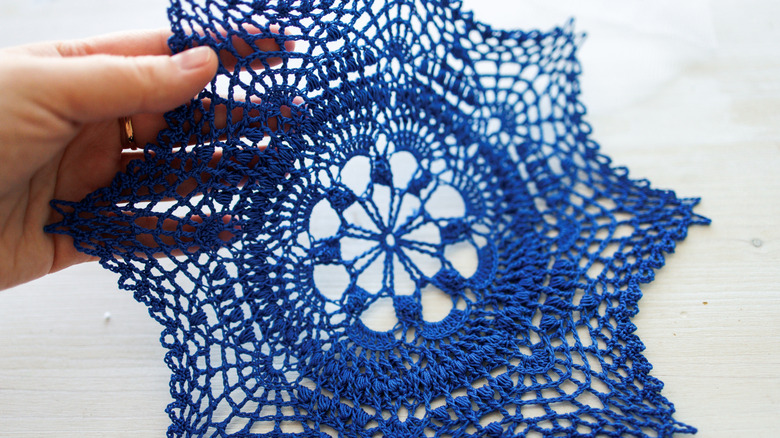 Person holding blue doily