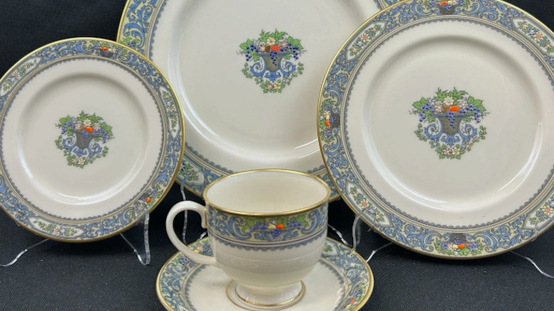 Set of Lenox Autumn dishes, 3 plates, cup and saucer on black background.