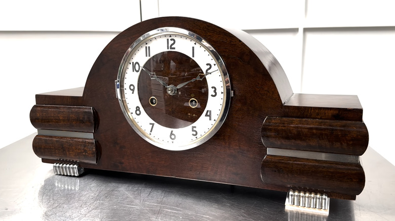 A vintage Art Deco FHS German hammer on coil strike mantle clock sits on a metal table