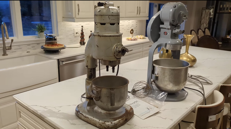 Two vintage KitchenAid Hobart Mixers sit on a white kitchen countertop