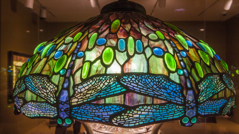 A blue and green dragonfly motif Tiffany lampshade is illuminated