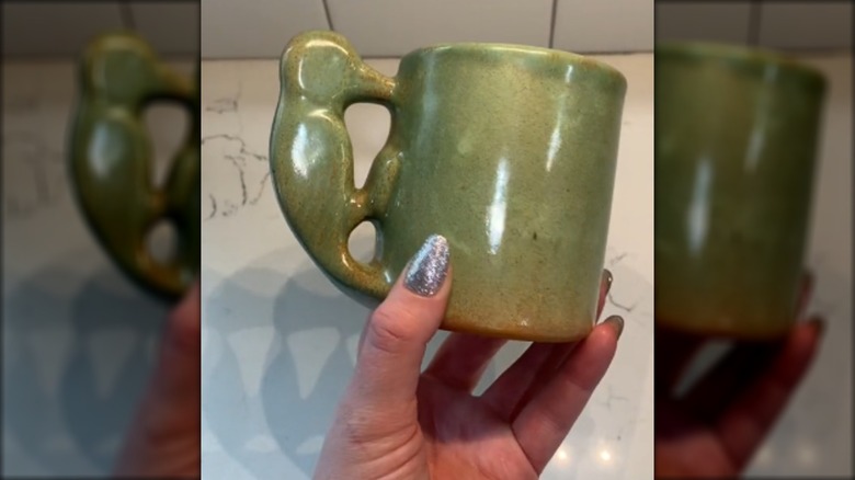Woman holding thrifted Shearwater Pottery mug