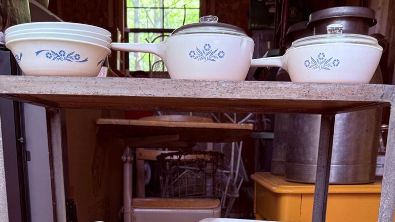 An assortment of vintage Corningware dishes and pans in the Cornflower pattern.