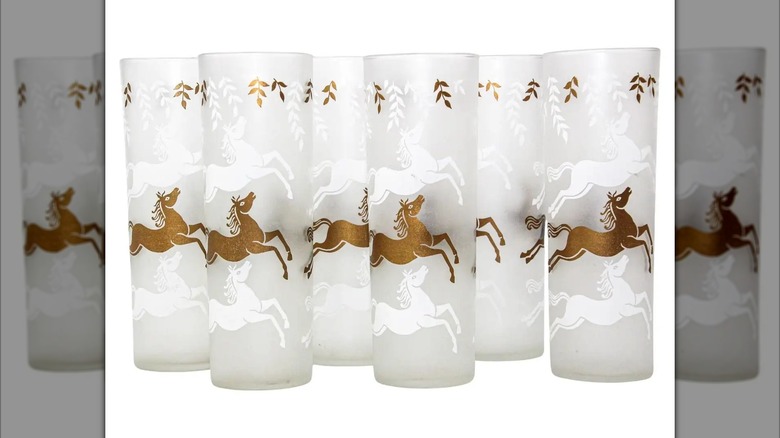 A collection of Equestrian Frosted and Gold Drink Glasses Cavalcade by Libbey Glass Company are shown in a detail shot