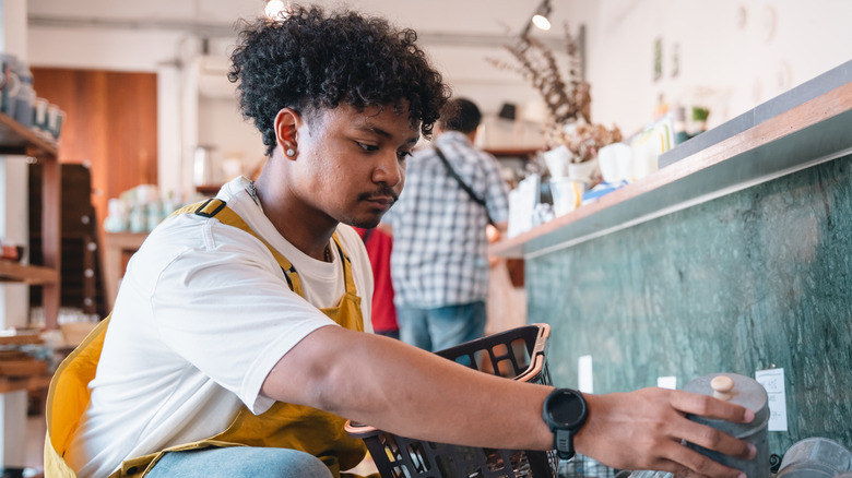 A young man shopping for vintage cookie jars at thrift store