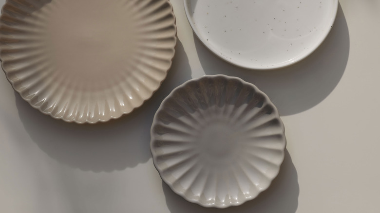 collection of neutral colored plates on a beige table