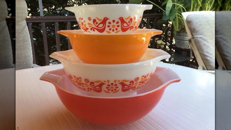 A stack of Pyrex Friendship Cinderella bowls on an outdoor table