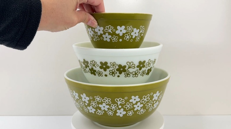 Woman holding smallest mixing bowl from the vintage Pyrex Spring Blossom three-piece set