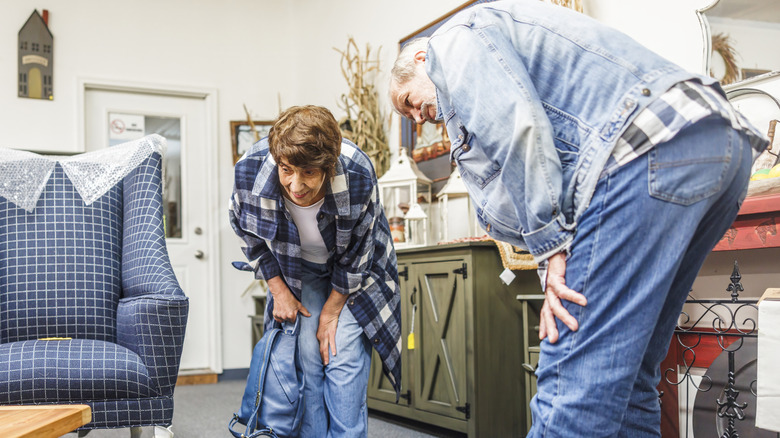 Couple inspecting thrift store furniture