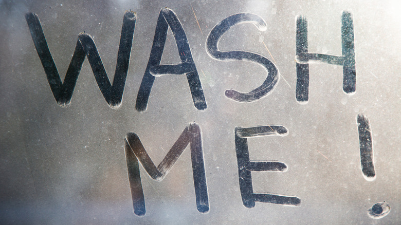a very dirty window with the words wash me written on it