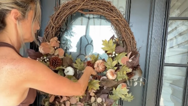 A woman makes an extra large fall wreath
