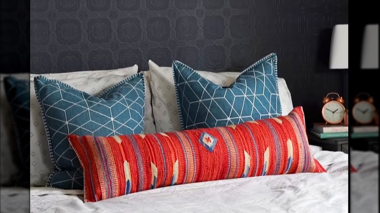 Colorful throw pillows with vintage rug patterns on a bed