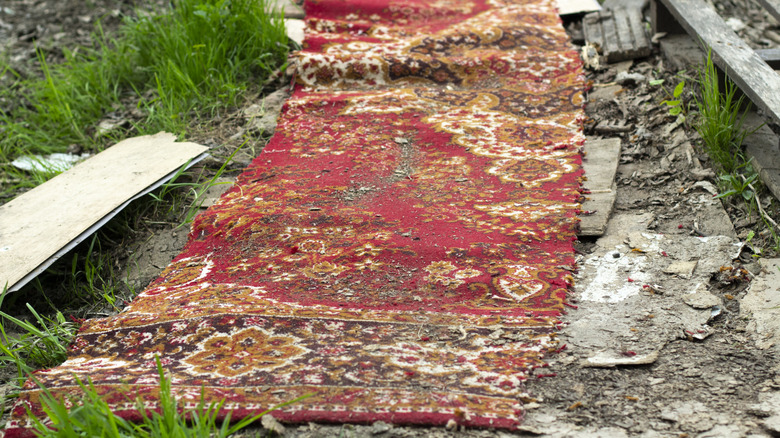 An old rug laid down outside for weed suppression