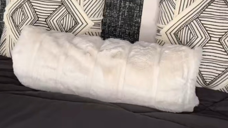 White fluffy lumbar pillow made from rolled-up fabric